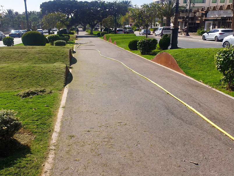 Espaces verts aménagés avec bordures courbes en acier Corten le long d’un chemin piéton à Agadir