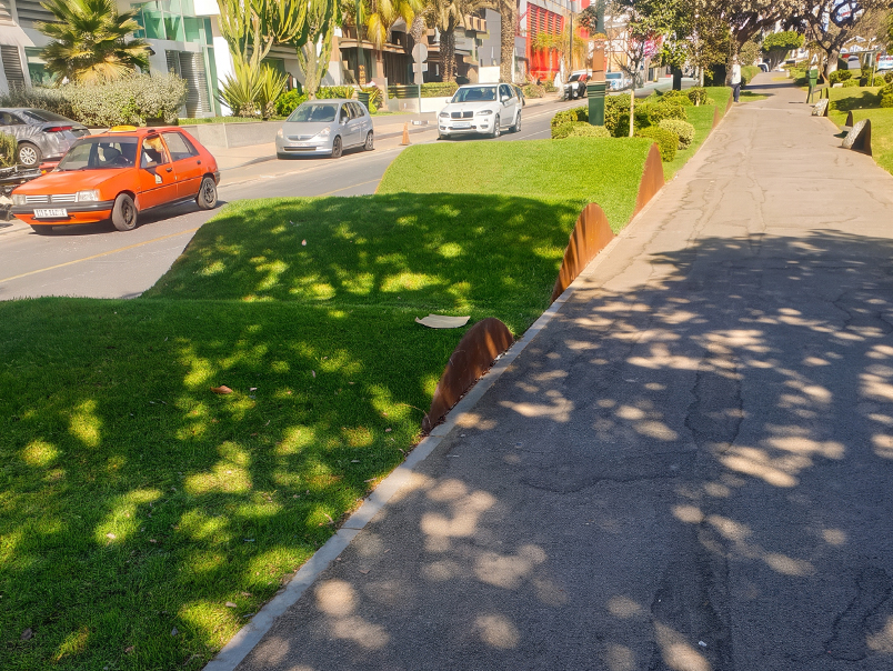 Bordures ondulées en acier Corten délimitant des espaces engazonnés le long d’un boulevard à Agadir