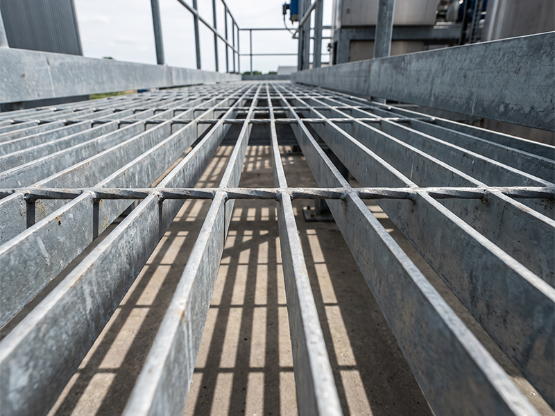 Caillebotis métallique galvanisé installé sur une passerelle technique dans un environnement industriel
