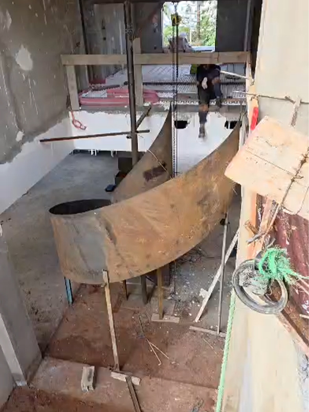 Vue en hauteur d’un escalier hélicoïdal métallique en cours de réalisation dans une villa privée