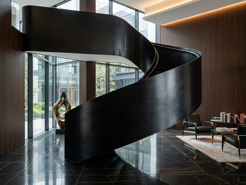 Escalier hélicoïdal contemporain en métal noir intégré dans un intérieur haut de gamme avec grandes baies vitrées