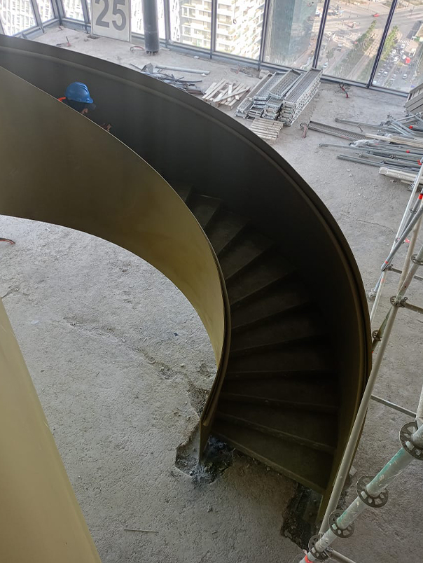 Vue plongeante d’un escalier hélicoïdal en acier installé dans un chantier de grande hauteur