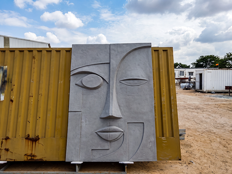 Moule en cours de préparation pour la fabrication d’une œuvre murale représentant un visage abstrait en relief
