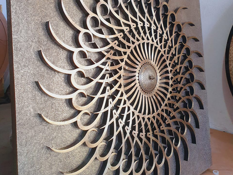 Vue latérale d’une œuvre murale géométrique en métal en cours de fabrication avec éléments en relief