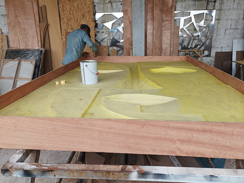 Œuvre murale représentant un visage abstrait en relief pendant sa phase de fabrication avant installation