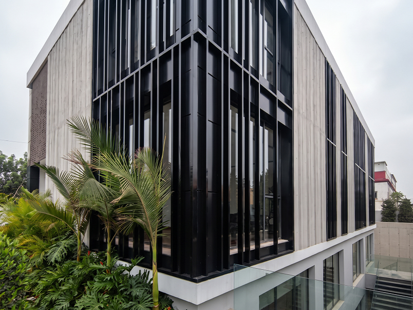 Brise-soleil verticaux métalliques noirs devant les fenêtres du siège Anfa Realties à Casablanca