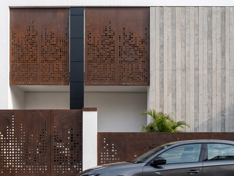 Façade du siège Anfa Realties avec grands panneaux perforés en acier Corten et clôture assortie