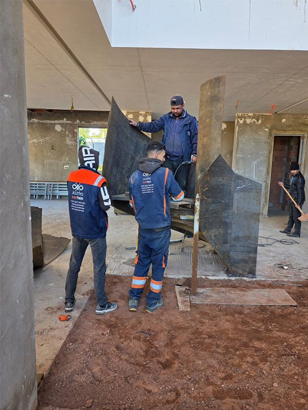 Équipe JOJMA installant un escalier hélicoïdal métallique sur mesure dans une villa privée