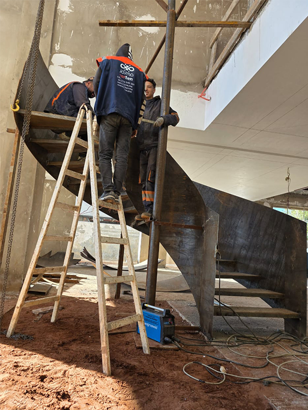 Techniciens JOJMA assemblant la structure d’un escalier hélicoïdal métallique dans une villa privée
