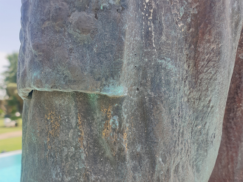 Détail de la patine verte et brune sur la surface texturée de la Sculpture Peigne