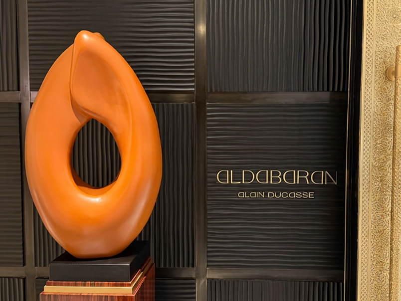 Sculpture abstraite orange aux formes organiques installée dans l’espace Aldebaran Alain Ducasse