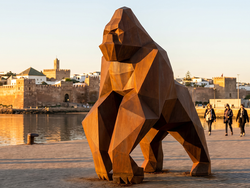 Sculpture monumentale de gorille origami avec finition acier Corten installée en extérieur.