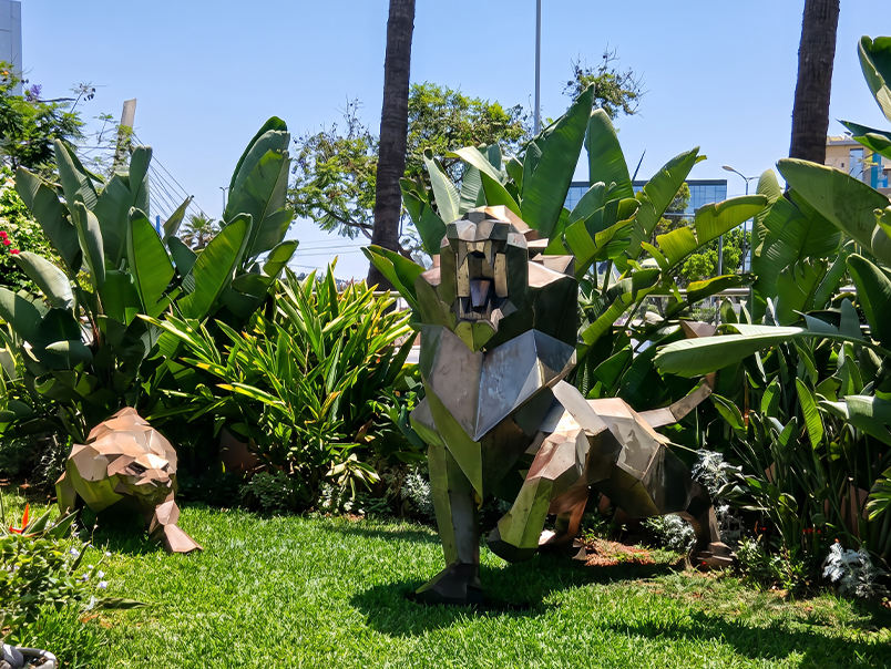 Sculpture origami de lion en métal installée dans un jardin paysager contemporain.