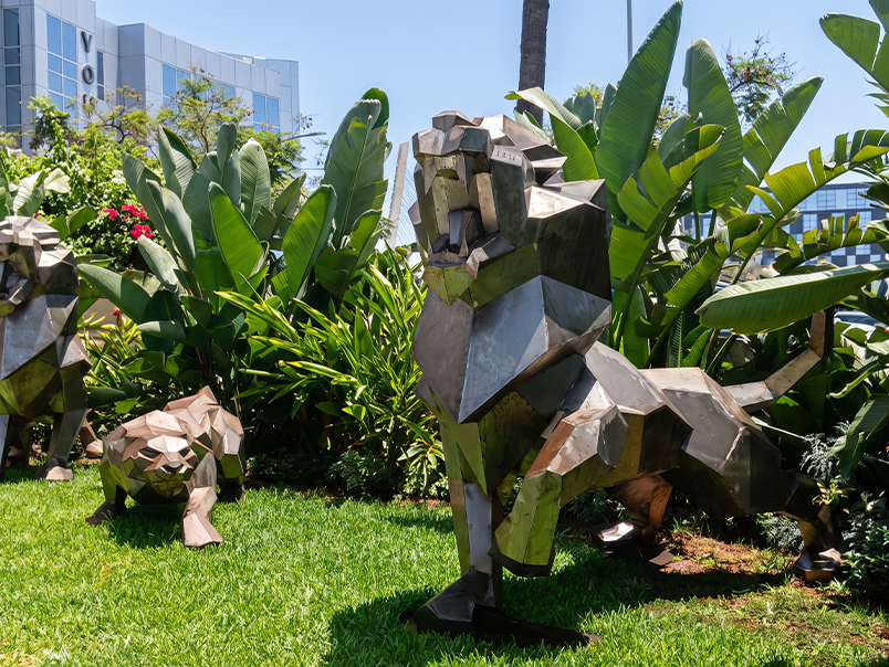 Sculpture origami de lion en métal installée dans le jardin d’une résidence contemporaine.
