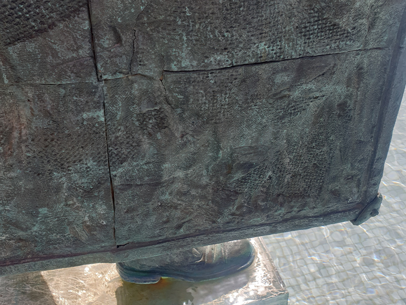 Gros plan sur la texture et la patine verdâtre du bronze de la Sculpture Peigne
