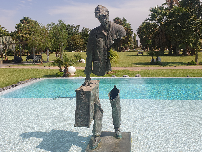 Sculpture Peigne en bronze patiné installée dans un jardin avec bassin et végétation