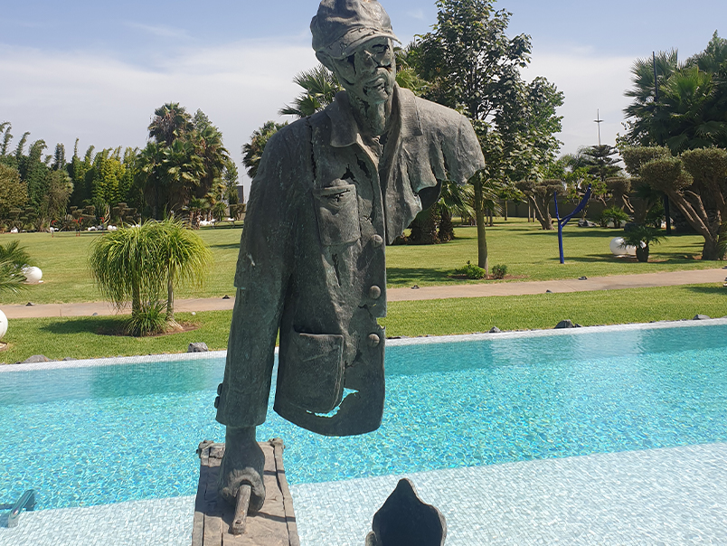 Personnage figuratif de la Sculpture Peigne en bronze patiné dans un jardin paysager