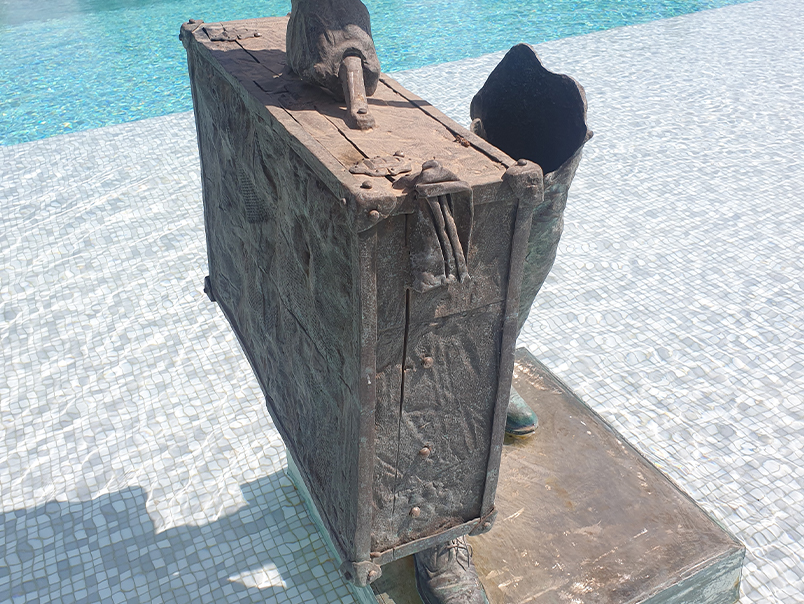 Valise en bronze patiné avec détails sculptés intégrée à une sculpture figurative contemporaine