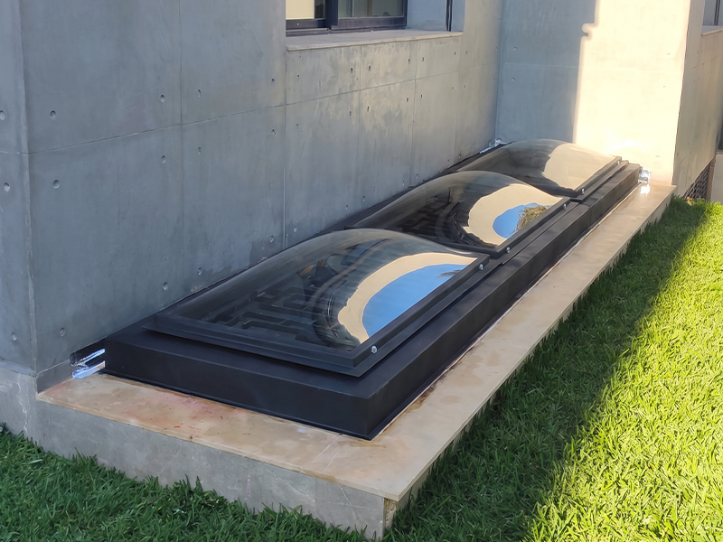 Skydomes vitrés sur mesure installés en toiture basse le long d’une façade contemporaine