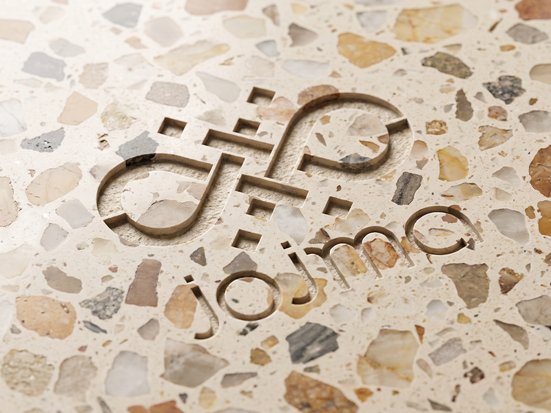 Surface en terrazzo clair avec agrégats naturels et logo JOJMA gravé